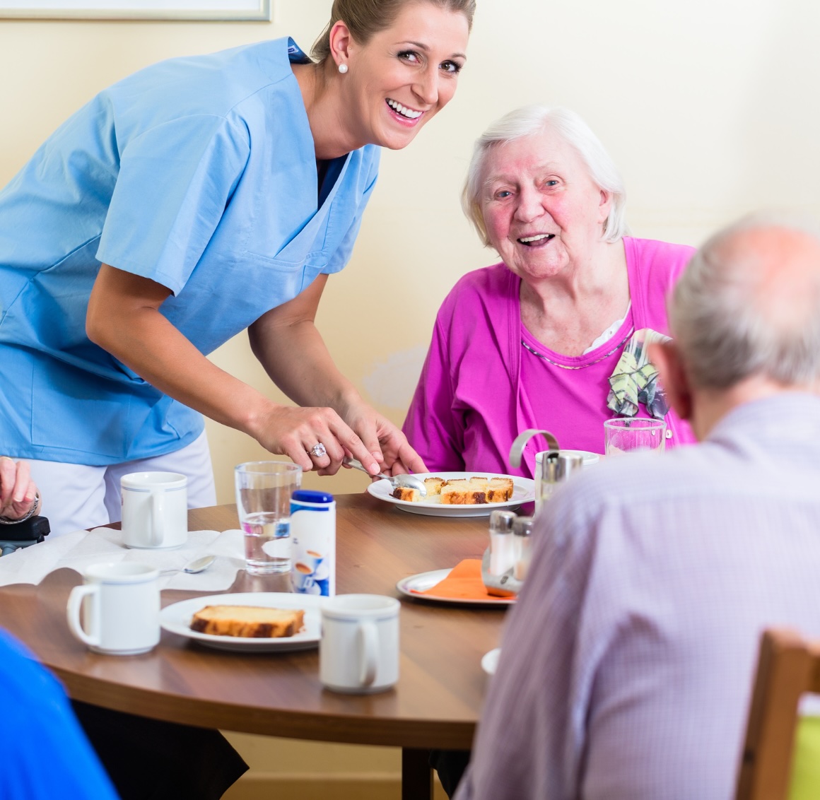 A caregiver brings a meal to a couple representing meal preparation in Reno.