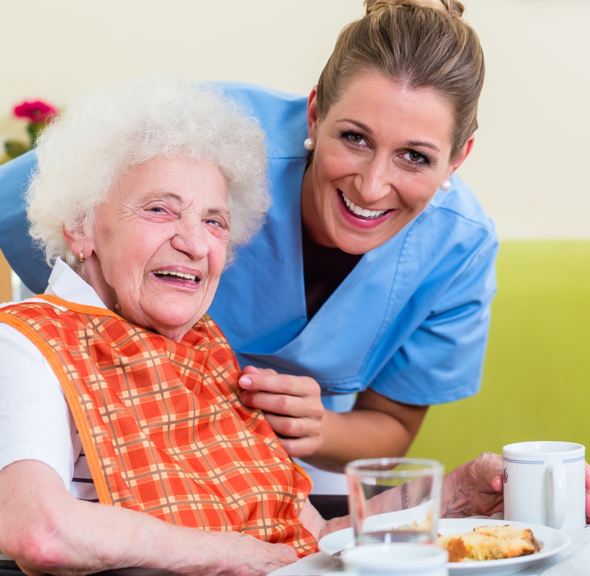 A caregiver helps an older client with her food representing meal preparation in Reno